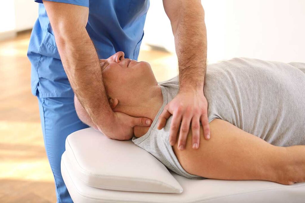 Person sitting on a couch gently stretching their neck and shoulders in a relaxed home setting.