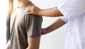 A chiropractor and physical therapist collaboratively discussing a patient's spine X-ray.