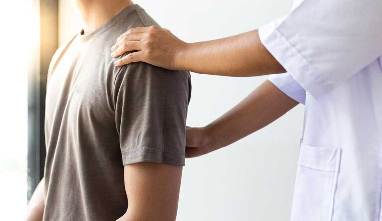 A chiropractor and physical therapist collaboratively discussing a patient's spine X-ray.